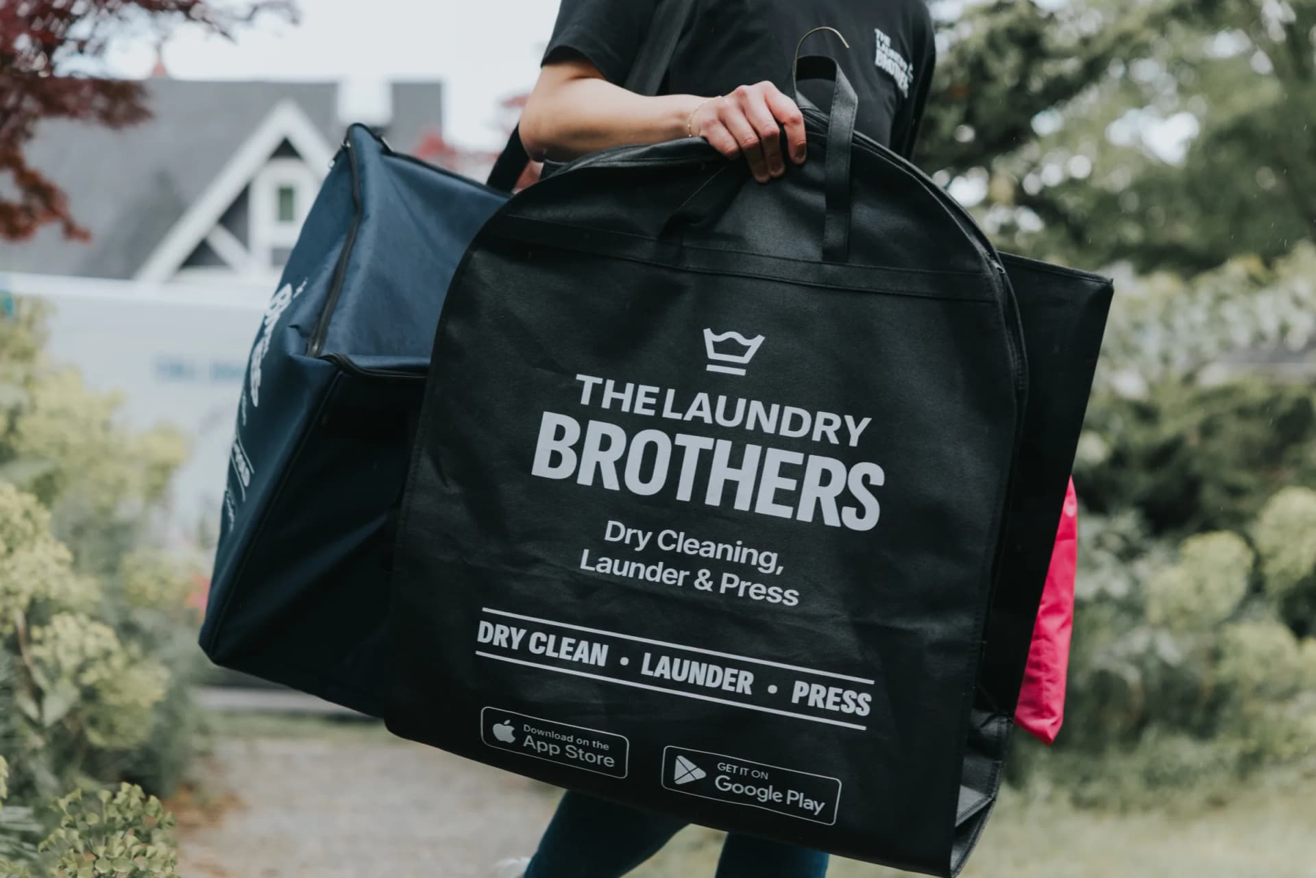 Driver smiling while delivering laundry bags in a residential neighbourhood.