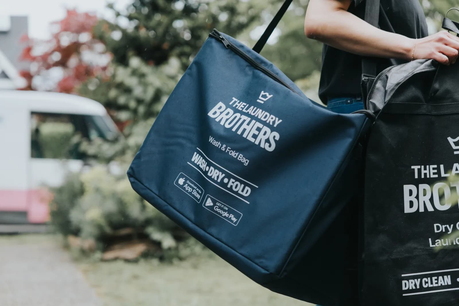 A Laundry Brothers driver delivering a wash & fold bag at a Point Grey doorstep.