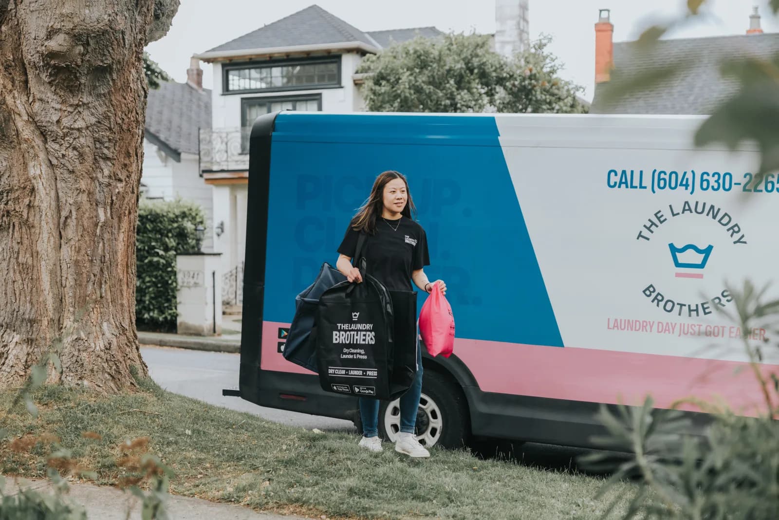 A Laundry Brothers driver next to the branded delivery van in a Vancouver neighbourhood.