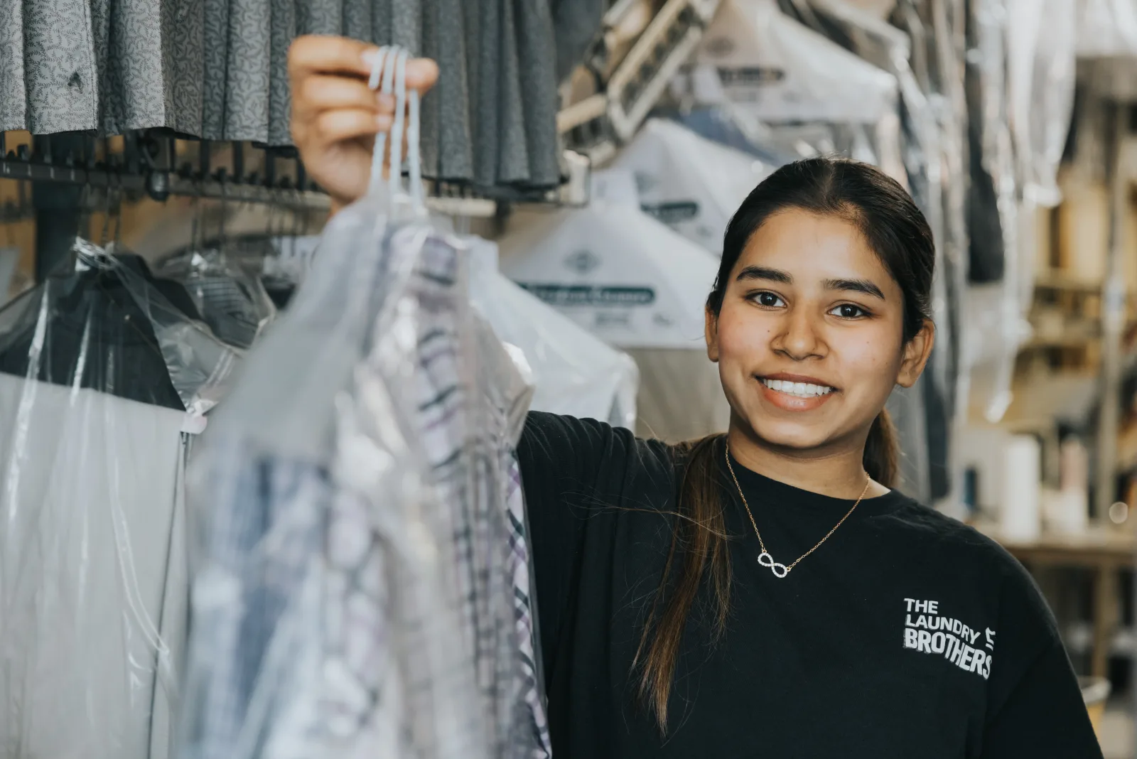 A Laundry Brothers staff member with a freshly cleaned and folded order ready for return.
